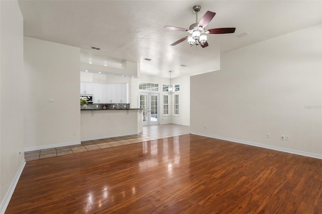 10303 SW 21st Ave, Gainesville, FL 32607 - unfurnished living room with wood-type flooring, a ceiling fan, and baseboards