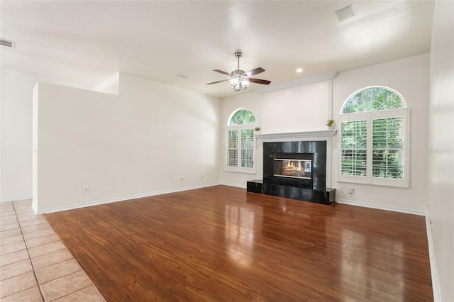 10303 SW 21st Ave, Gainesville, FL 32607 - unfurnished living room featuring ceiling fan, wood finished floors, a tiled fireplace, baseboards, and recessed lighting