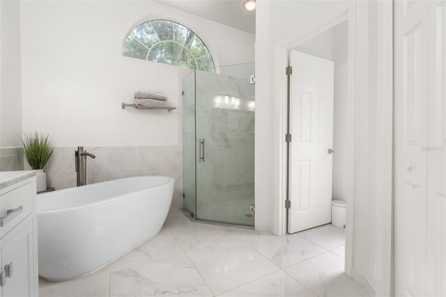 10303 SW 21st Ave, Gainesville, FL 32607 - full bath with marble look tiles, a marble finish shower, a soaking tub, tile walls, and vanity