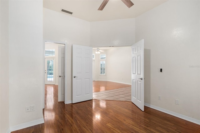 10303 SW 21st Ave, Gainesville, FL 32607 - unfurnished bedroom with hardwood / wood-style flooring, multiple windows, a high ceiling, baseboards, and ceiling fan