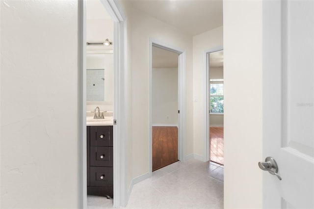 10303 SW 21st Ave, Gainesville, FL 32607 - corridor with light tile patterned floors, a sink, and baseboards