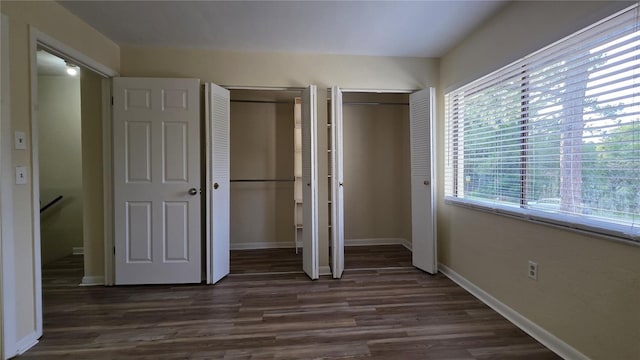 2635 SW 35th Pl Unit 1705, Gainesville, FL 32608 - unfurnished bedroom with multiple closets, dark wood-style flooring, and baseboards