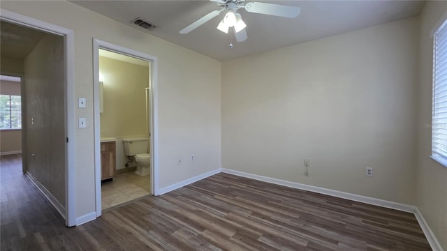 2635 SW 35th Pl Unit 1705, Gainesville, FL 32608 - unfurnished bedroom with dark wood-type flooring, baseboards, ensuite bathroom, and a ceiling fan