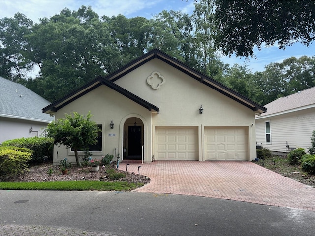10130 SW 48th Pl, Gainesville, FL 32608 - view of front of property featuring stucco siding, decorative driveway, and an attached garage