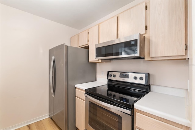 2360 SW Archer Rd Unit 204, Gainesville, FL 32608 - kitchen with stainless steel appliances, light brown cabinets, light countertops, light wood finished floors, and baseboards