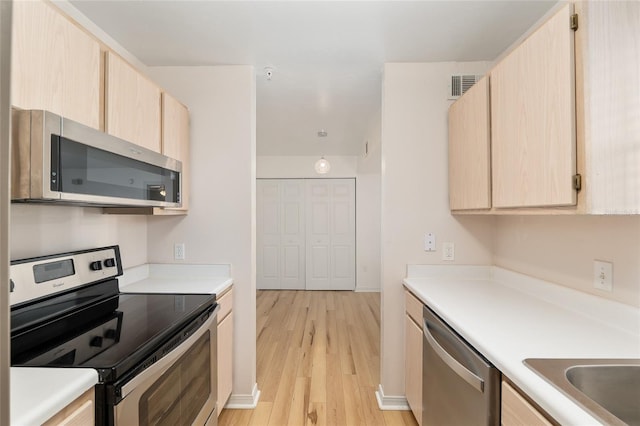 2360 SW Archer Rd Unit 204, Gainesville, FL 32608 - kitchen featuring appliances with stainless steel finishes, light brown cabinets, light countertops, and light wood-type flooring