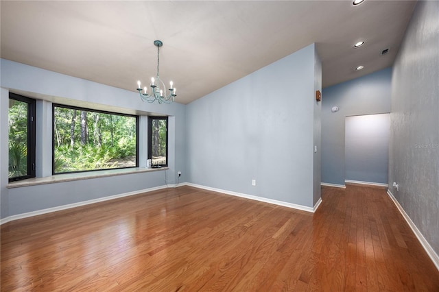 6425 NW 97th Ct, Gainesville, FL 32653 - empty room featuring a chandelier, wood finished floors, recessed lighting, baseboards, and lofted ceiling