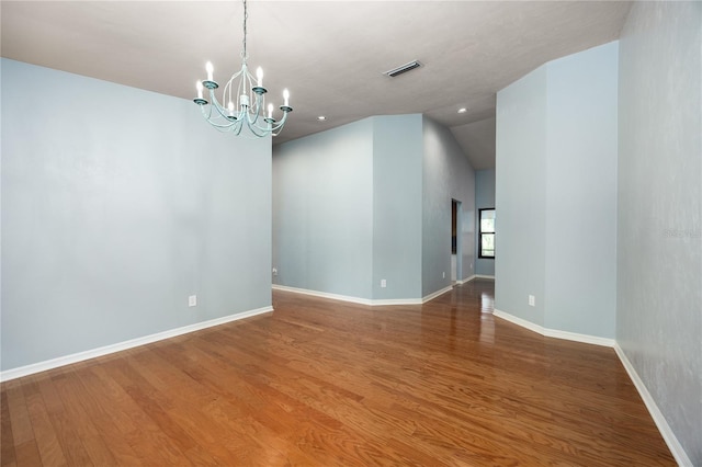 6425 NW 97th Ct, Gainesville, FL 32653 - spare room featuring wood finished floors, a chandelier, baseboards, vaulted ceiling, and recessed lighting