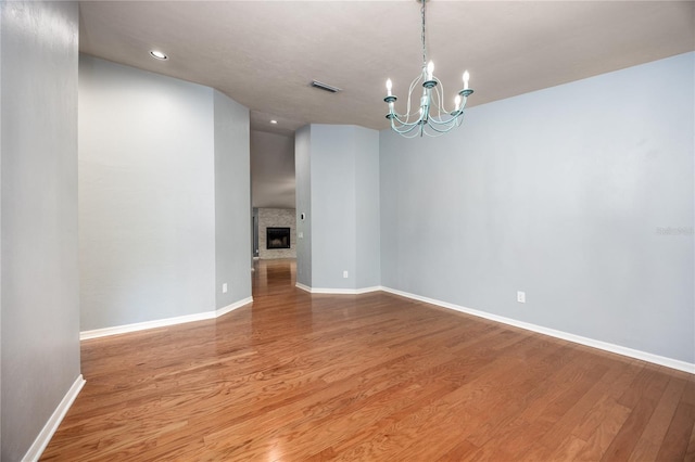 6425 NW 97th Ct, Gainesville, FL 32653 - empty room featuring a chandelier, baseboards, wood finished floors, recessed lighting, and a fireplace
