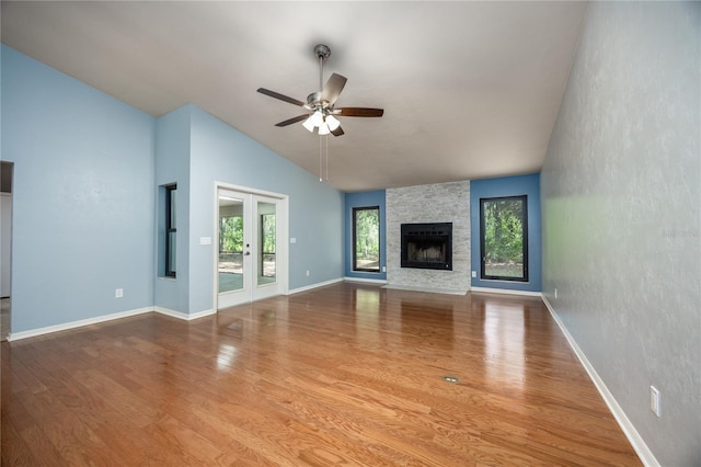 6425 NW 97th Ct, Gainesville, FL 32653 - unfurnished living room featuring a ceiling fan, lofted ceiling, wood finished floors, a fireplace, and baseboards