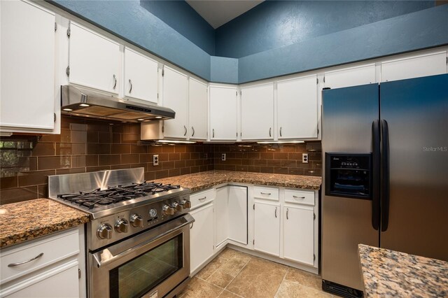 6425 NW 97th Ct, Gainesville, FL 32653 - kitchen featuring stainless steel appliances, under cabinet range hood, tasteful backsplash, white cabinets, and dark stone counters