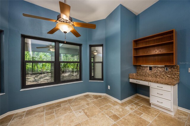 6425 NW 97th Ct, Gainesville, FL 32653 - unfurnished office with built in desk, stone tile floors, a ceiling fan, and baseboards