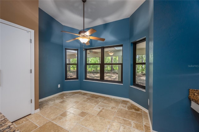 6425 NW 97th Ct, Gainesville, FL 32653 - unfurnished room featuring stone tile flooring, baseboards, and a ceiling fan