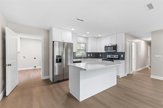 3237 NW 30th Ave, Gainesville, FL 32605 - kitchen with stainless steel appliances, a sink, wood finished floors, baseboards, and recessed lighting