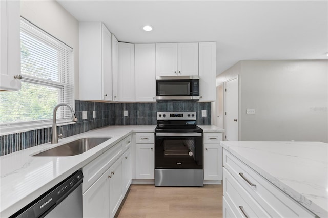 3237 NW 30th Ave, Gainesville, FL 32605 - kitchen with appliances with stainless steel finishes, a sink, backsplash, white cabinetry, and recessed lighting