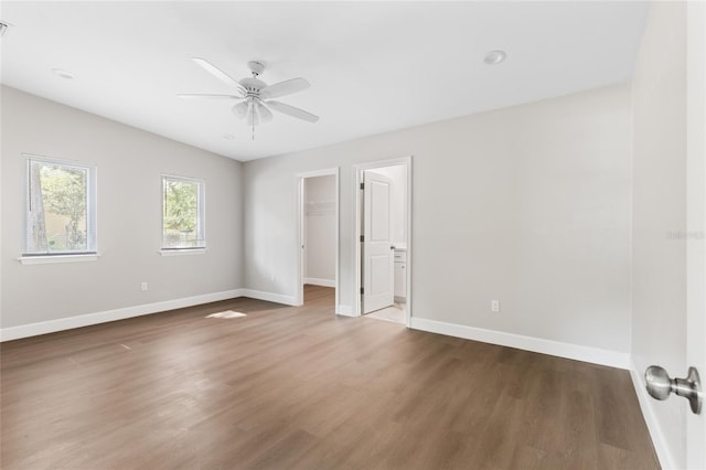 3237 NW 30th Ave, Gainesville, FL 32605 - unfurnished bedroom featuring wood finished floors, baseboards, a spacious closet, and a ceiling fan