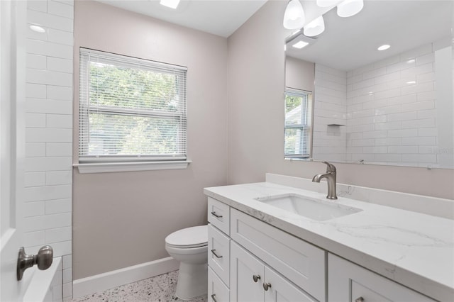 3237 NW 30th Ave, Gainesville, FL 32605 - bathroom with vanity, baseboards, toilet, and speckle patterned floor