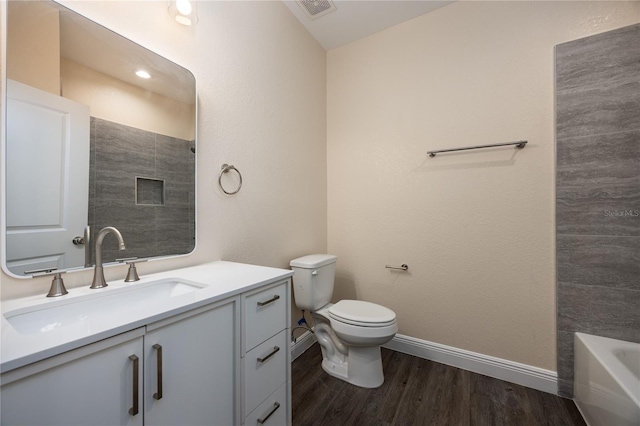 15217 NW 134th Ter, Alachua, FL 32615 - bathroom featuring vanity, wood finished floors, toilet, a tub to relax in, and baseboards