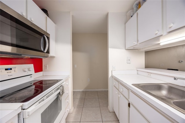 3921 SW 34th St Unit 106, Gainesville, FL 32608 - kitchen with electric stove, stainless steel microwave, light tile patterned floors, and light countertops