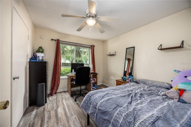3921 SW 34th St Unit 106, Gainesville, FL 32608 - bedroom with wood finished floors, an office area, and a ceiling fan
