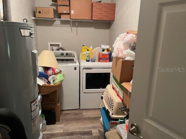 633 SW Magnolia Ave, Keystone Heights, FL 32656 - laundry area with washer and dryer, water heater, and wood finished floors