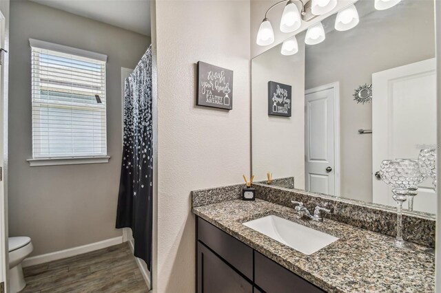 13201 Orca Sound Dr, Riverview, FL 33579 - bathroom featuring vanity, wood finished floors, toilet, and baseboards