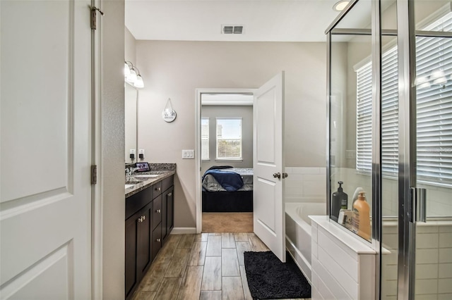 13201 Orca Sound Dr, Riverview, FL 33579 - full bath featuring vanity, wood finished floors, a garden tub, and connected bathroom