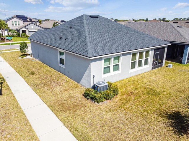 13201 Orca Sound Dr, Riverview, FL 33579 - view of side of property featuring a shingled roof, stucco siding, central AC unit, and a yard