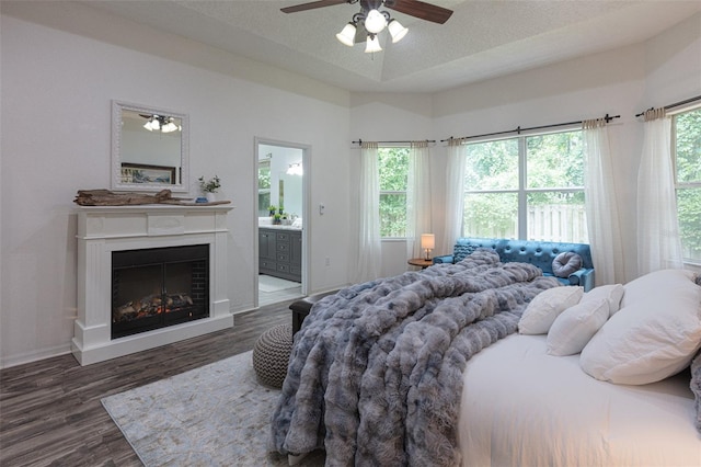 2072 SW 66th Dr, Gainesville, FL 32607 - bedroom featuring wood finished floors, a fireplace, ensuite bathroom, a ceiling fan, and a textured ceiling