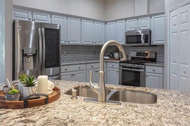 2072 SW 66th Dr, Gainesville, FL 32607 - kitchen featuring stainless steel appliances, backsplash, and light stone countertops