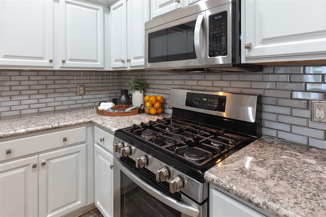 2072 SW 66th Dr, Gainesville, FL 32607 - kitchen featuring appliances with stainless steel finishes, tasteful backsplash, white cabinets, and light stone counters