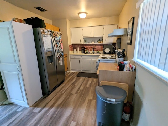 14230 SW 167th St, Archer, FL 32618 - kitchen featuring stainless steel fridge with ice dispenser, under cabinet range hood, a sink, tasteful backsplash, and dark wood-style floors