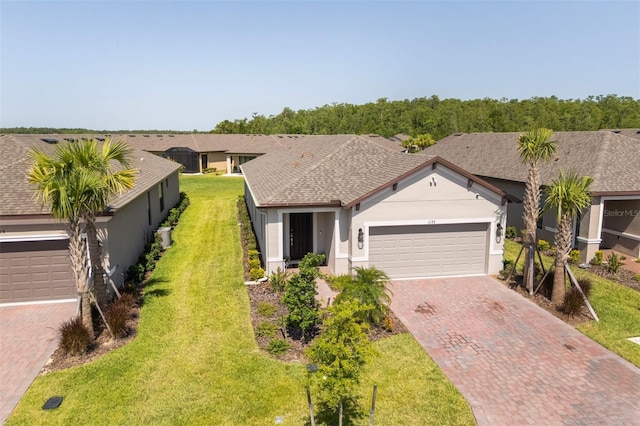 1192 Via Galuppi St, Poinciana, FL 34759 - single story home with decorative driveway, stucco siding, a garage, a front lawn, and roof with shingles