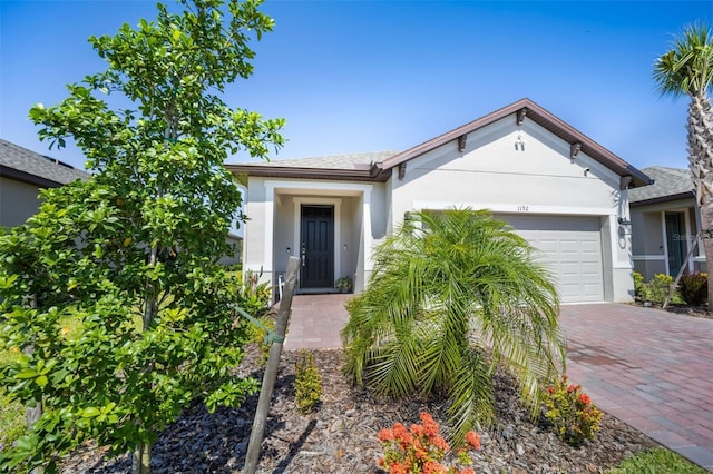 1192 Via Galuppi St, Poinciana, FL 34759 - single story home featuring a garage, stucco siding, decorative driveway, and a shingled roof