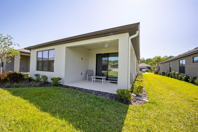 1192 Via Galuppi St, Poinciana, FL 34759 - rear view of house with stucco siding, a yard, and a patio area