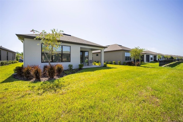 1192 Via Galuppi St, Poinciana, FL 34759 - rear view of property featuring stucco siding and a yard