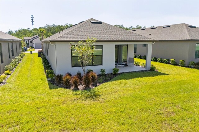 1192 Via Galuppi St, Poinciana, FL 34759 - rear view of house featuring roof with shingles, a lawn, stucco siding, and a patio area
