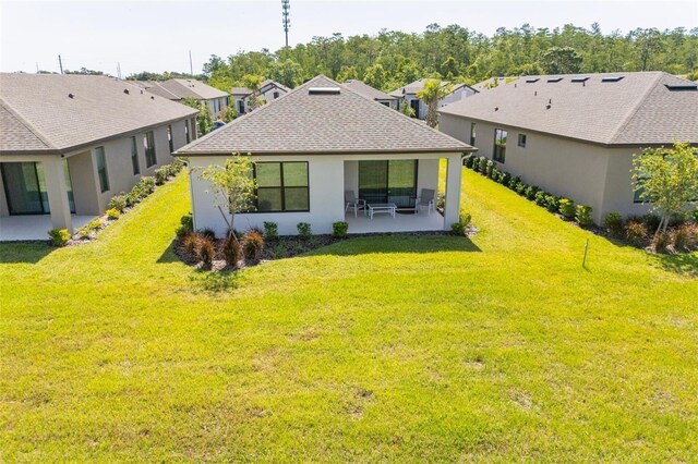 1192 Via Galuppi St, Poinciana, FL 34759 - rear view of house featuring a patio, a lawn, a residential view, stucco siding, and roof with shingles