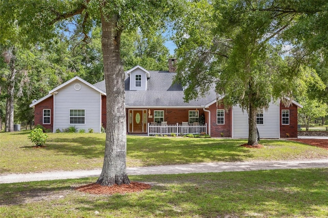 1827 SW Shiloh St, Fort White, FL 32038 - view of front of house with covered porch, a chimney, a front yard, and brick siding