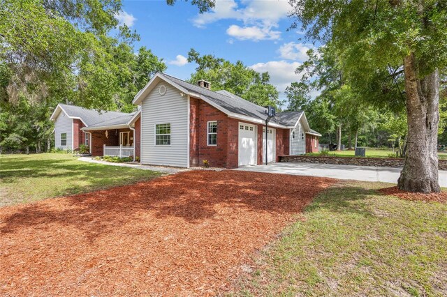 1827 SW Shiloh St, Fort White, FL 32038 - view of front facade with an attached garage, a front lawn, concrete driveway, brick siding, and a porch