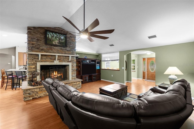 1827 SW Shiloh St, Fort White, FL 32038 - living area with a ceiling fan, arched walkways, lofted ceiling, light wood-type flooring, and a stone fireplace