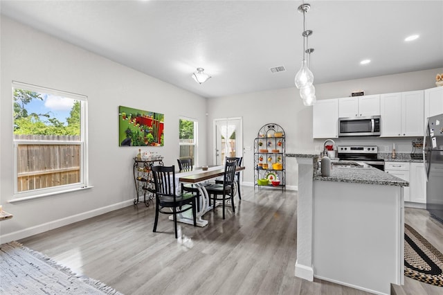 14214 NW 154th Pl, Alachua, FL 32615 - kitchen with stainless steel appliances, healthy amount of natural light, light wood-type flooring, light stone countertops, and recessed lighting
