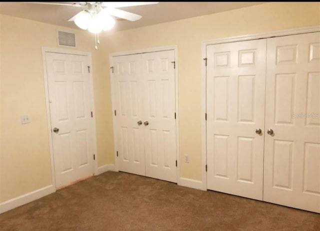 2915 SW 35th Pl Unit 102, Gainesville, FL 32608 - unfurnished bedroom featuring two closets, carpet flooring, baseboards, and a ceiling fan