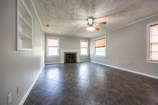 1404 NW 10th Ave, Gainesville, FL 32605 - unfurnished living room featuring healthy amount of natural light, a ceiling fan, crown molding, a textured ceiling, and a tiled fireplace