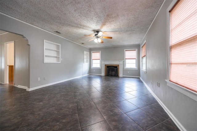 1404 NW 10th Ave, Gainesville, FL 32605 - unfurnished living room featuring a ceiling fan, arched walkways, a fireplace, ornamental molding, and a textured ceiling