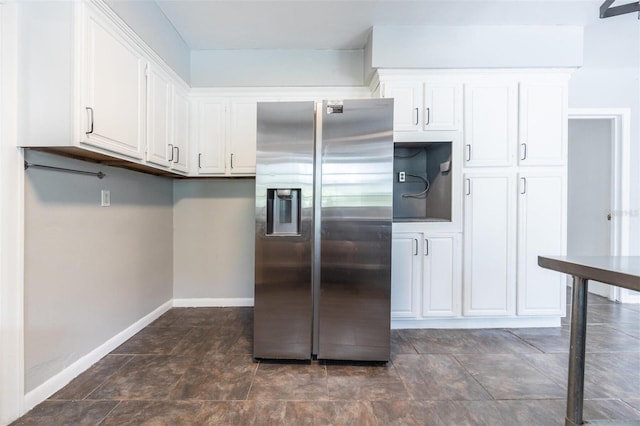 1404 NW 10th Ave, Gainesville, FL 32605 - kitchen with stainless steel fridge, white cabinets, and stone finish floors