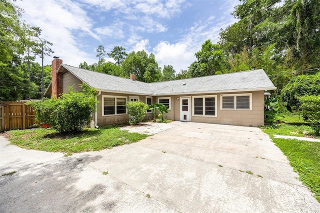1404 NW 10th Ave, Gainesville, FL 32605 - ranch-style house with concrete driveway, a chimney, and a shingled roof