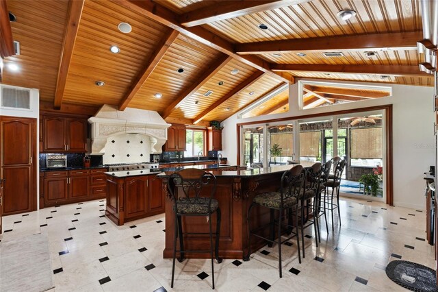 518 SW Little Rd, Lake City, FL 32024 - kitchen featuring dark countertops, a spacious island, wood ceiling, backsplash, and baseboards
