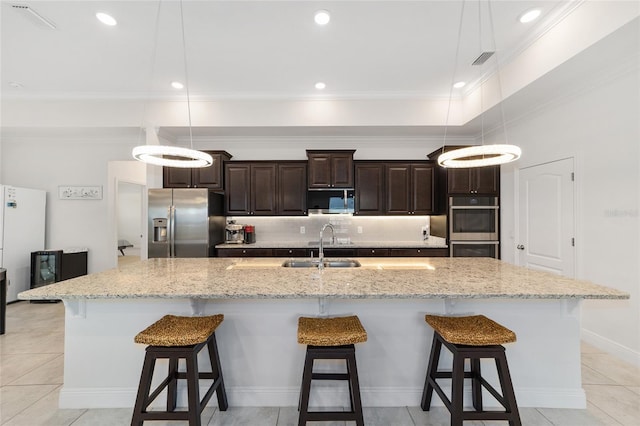 5604 SW 215th Ter, Newberry, FL 32669 - kitchen with appliances with stainless steel finishes, a kitchen breakfast bar, dark brown cabinetry, a spacious island, and backsplash