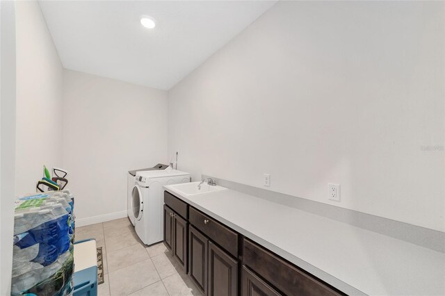5604 SW 215th Ter, Newberry, FL 32669 - washroom with washing machine and clothes dryer, cabinet space, and light tile patterned flooring